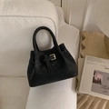Close-up of black bucket bag with gold square buckle and matte texture on a white sofa - Black without Pendant