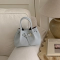 Close-up of light blue bucket bag with knotted leather strap and gold metal hardware detail - Blue Without Charm