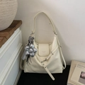 Detailed close-up of cream matte leather tote bag with silver flower charm and adjustable strap - Beige With Charm