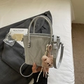Bolso cubo gris claro de textura plisada con asa de bola metálica y colgante de oso - Plateado