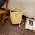 Detail of yellow bucket bag with lychee texture and metallic turn-lock closure - No Pendant / Yellow