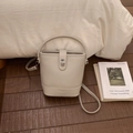 Detail of cream white pebbled leather bucket bag with silver turn-lock and handle - No Pendant / Gray