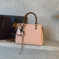 Détail du sac bandoulière rose clair avec poignées brunes et un charm de cheval élégant - Rose Avec Pendentif