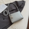 Close-up of minimalist grey underarm bag with silver crescent pendant and matte PU texture - With Pendant Style / Blue with Pendant