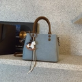 Detail of light blue canvas tote bag with leather handles and decorative pony charm - Blue with Pendant