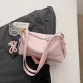 Piccola borsa sottobraccio in pelle rosa con tracolla regolabile su sfondo grigio - Rosa