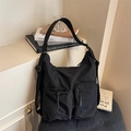 Dettaglio borsa a tracolla in nylon nero con tasche a coulisse e cinghie funzionali - Nero