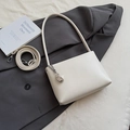 Detailed view of beige underarm bag with silver metal pendant on dark blazer background - With Pendant Style / White With Pendant