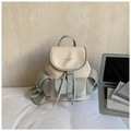 Close-up of contrast beige and green faux leather backpack with drawstring and flap closure - Blue