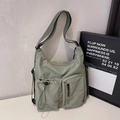 Dettaglio borsa a tracolla in nylon verde chiaro con coulisse e tasche con cerniera - Verde
