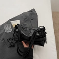 Dettaglio della borsa nera lucida con manici superiori e tracolla lunga regolabile - Nero