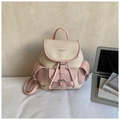 Detail of pink and cream faux leather backpack featuring a front pocket and metal buckles - Pink