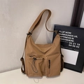 Dettaglio della borsa a tracolla kaki con tasche funzionali multiple e tessuto resistente - Marrone