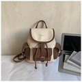 Macro detail of the contrast leather texture and drawstring closure on the vintage backpack - Brown