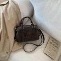 Detail view of dark brown Boston bag with embossed logo on premium matte texture - Coffee (No Pendant)