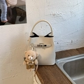Detail der cremeweißen Eimer-Tasche aus Leder mit Silberverschluss und Bärenanhänger - Weiß Mit Anhänger