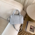 Detail of light blue Boston bag on sofa with soft lighting and stylish top handles - Blue (No Pendant)