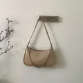 Bolso hobo minimalista de cuero beige con un elegante detalle de cadena plateada - Color Avena