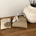 Vue détaillée du sac à main en cuir kaki avec foulard en soie et fermoir doré chic - Gris