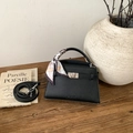 Détail du sac trapèze noir avec texture litchi et décor de foulard en soie sur l'anse - Noir