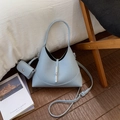 Primer plano del bolso saco en cuero azul claro con cierre plateado y mini monedero - Azul