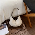Detalle de bolso bicolor con hebilla plateada y textura de cuero granulado de calidad - Beige Café
