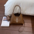 Detalle de bolso cubo de cuero marrón caramelo con hebilla plateada y mini monedero - Marrón