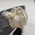 White drawstring bucket bag with a cute plush poodle charm and striped ribbon detail - With Charm / Off White