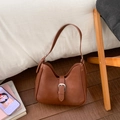 Detailed close-up of a semi-moon caramel brown shoulder bag with silver buckle accent - Brown