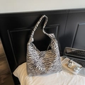 Dettaglio borsa hobo zebrata con tracolla annodata in un contesto di home office - Stampa Zebra Beige