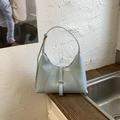 Detail of light blue crescent underarm bag with silver buckle and smooth faux leather finish - Blue