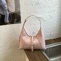 Detailed macro view of light pink crescent moon bag with silver buckle and matte leather texture - Pink