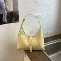 Detail view of a pale yellow hobo bag with smooth leather texture and metal buckle accents - Yellow