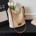 Dettaglio della borsa tote crema tessuta a mano con tracolla in pelle marrone sul tavolo - Bianco Sporco