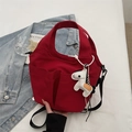 Close-up of red nylon tote bag featuring front pockets and a white pony charm decoration - Red (With Ornament)