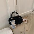 Macro shot of a vintage black Boston bag with gold hardware and a cute crochet bear charm - Black With Pendant