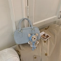 Détail du sac à main Boston bleu clair avec texture mate et charme d'ours en peluche - Bleu avec pendentif