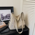 Detail view of khaki nylon tote bag featuring diagonal zipper and magnetic flap pocket - Khaki