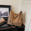 Detail view of large brown canvas tote bag with functional pockets and silver zipper details - Brown