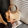 Chic beige bucket bag with brown leather handles and a bohemian wooden bead tassel charm - White & Khaki