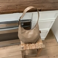 Detail view of khaki hobo bag with wide adjustable strap and silver metal eyelets - Khaki