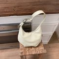 Detail of creamy white crescent shoulder bag with wide strap and silver buckle adjustment - Yellow