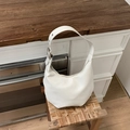 Detail shot of the silver metal adjustment buckle on white leather crescent hobo bag - White