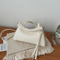 Detailansicht einer cremeweißen minimalistischen Tasche mit Metallkugelgriff und Gurt - Weiß