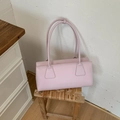 Detalle del bolso baguette de cuero lila claro que muestra las costuras y la textura - Morado