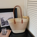 Detalle de bolso tote de paja trenzada con rayas marrones y asas de cuero fino - Blanco Roto