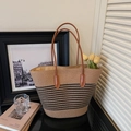 Detalle de bolso de paja trenzada caqui con rayas negras y asas de cuero marrón - Negro y Caqui