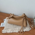 Detail einer minimalistischen khakifarbenen Ledertasche mit Kordelzug und Metallschnalle - Khaki