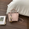 Pink matte leather bucket bag with silver hardware and a beige woven flower charm - Pink with Pendant