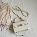 Cremefarbene strukturierte Mini-Handtasche mit silbernem Drehverschluss und Herzanhänger - Beige mit Herzanhänger